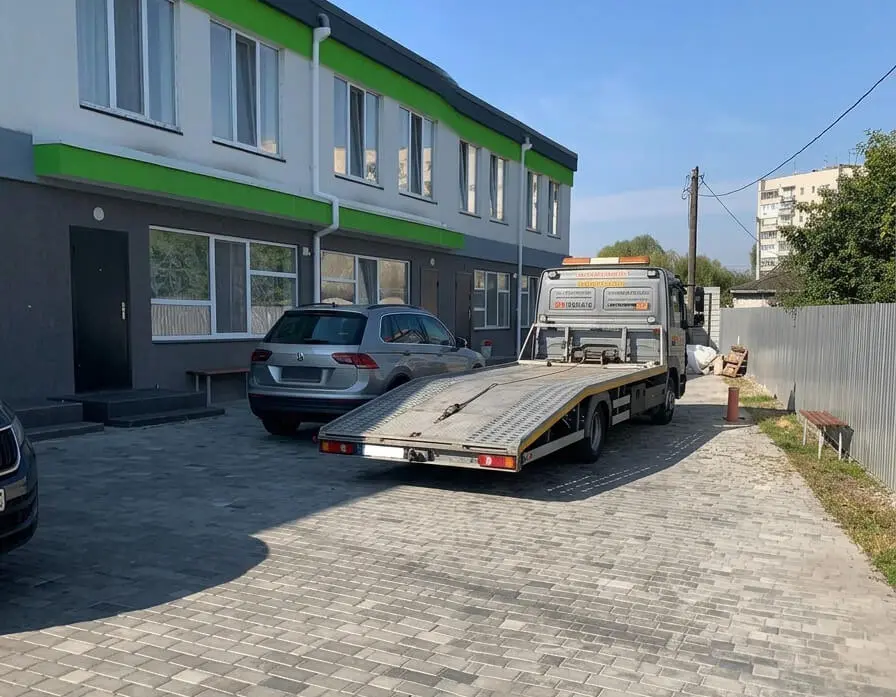 Евакуатор із відкинутою платформою біля автосервісу на вулиці Шевченка в Борисполі