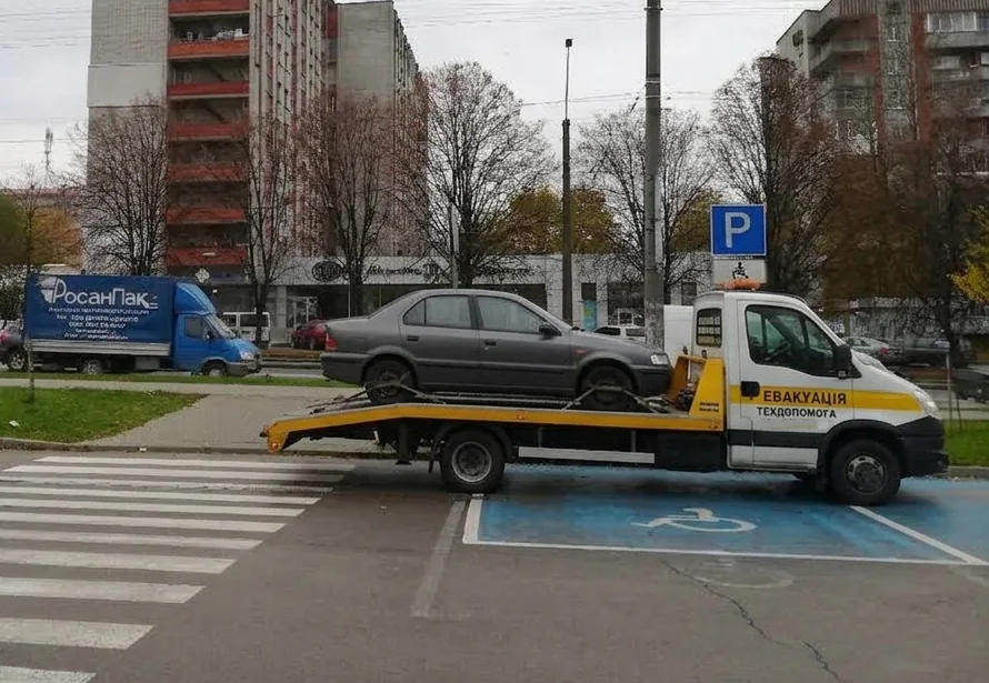Евакуатор із завантаженим легковим автомобілем у житловому районі Львова